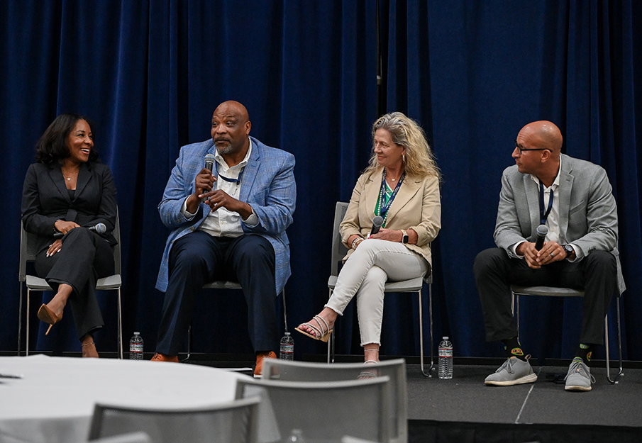 Samantha Vance, Ervin Lewis, Tammie Talley and Alex Alston sitting on platform with microphones in hands