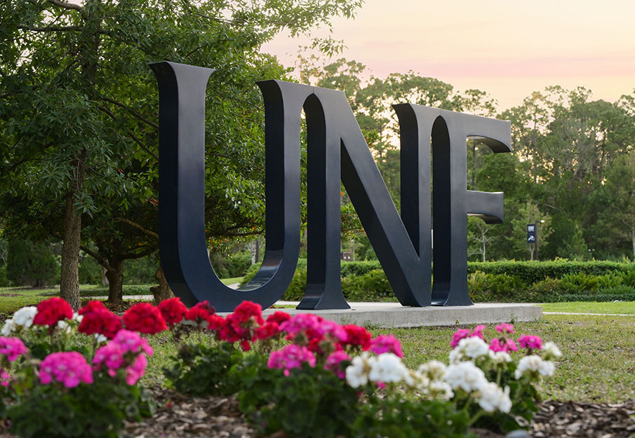 UNF letters sign with pink flowers in foreground