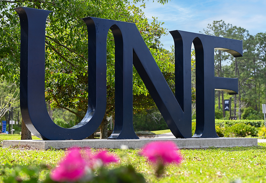 UNF letters sign with pink flowers in foreground