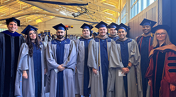 First FinTech graduating cohort standing together in their caps and gowns