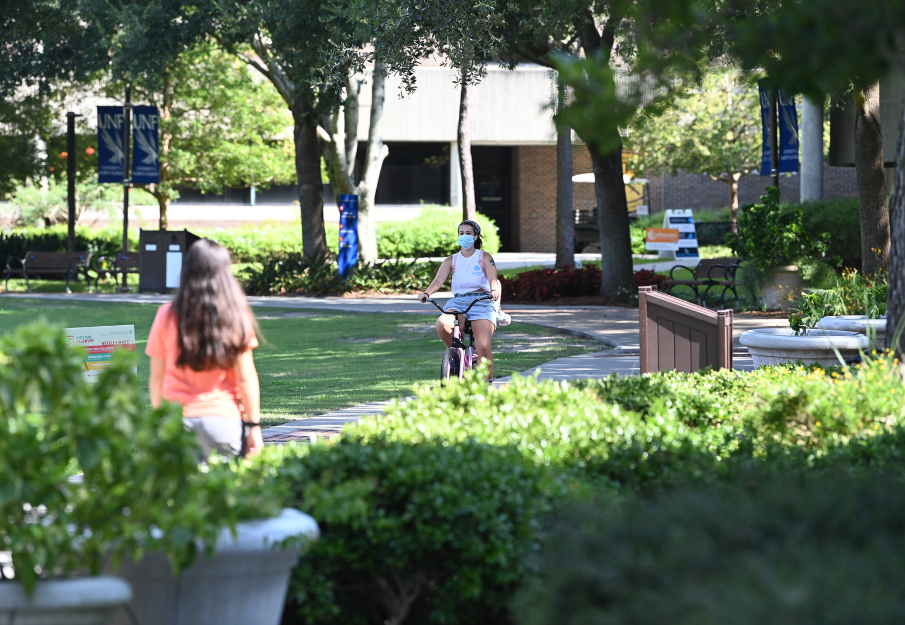 Student riding bike on campus