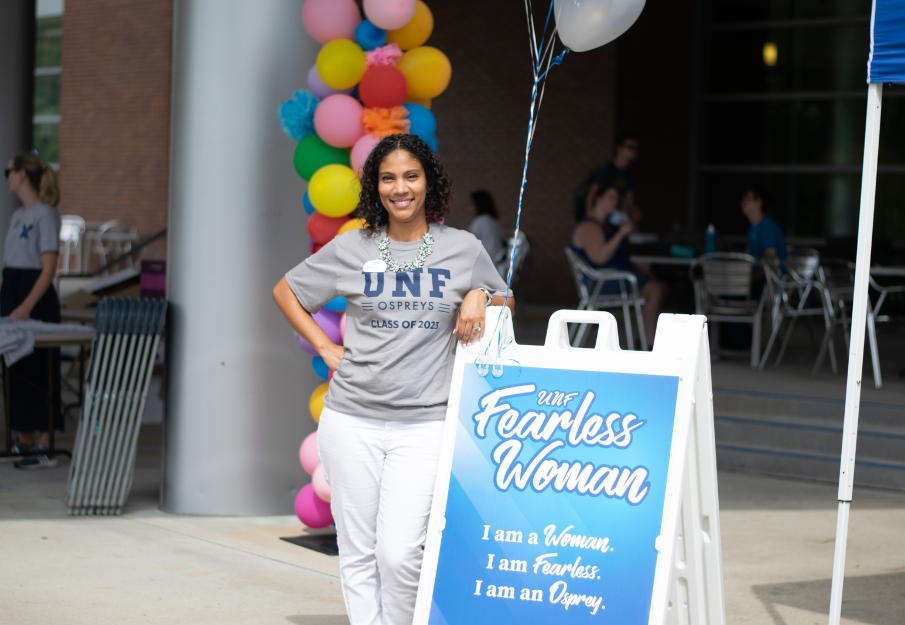 VP Whitney Meyer standing in front of a UNF Fearless Women sign in the Student Union