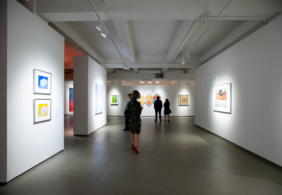 Gallery at MOCA with a few patrons walking through and looking at the art displays