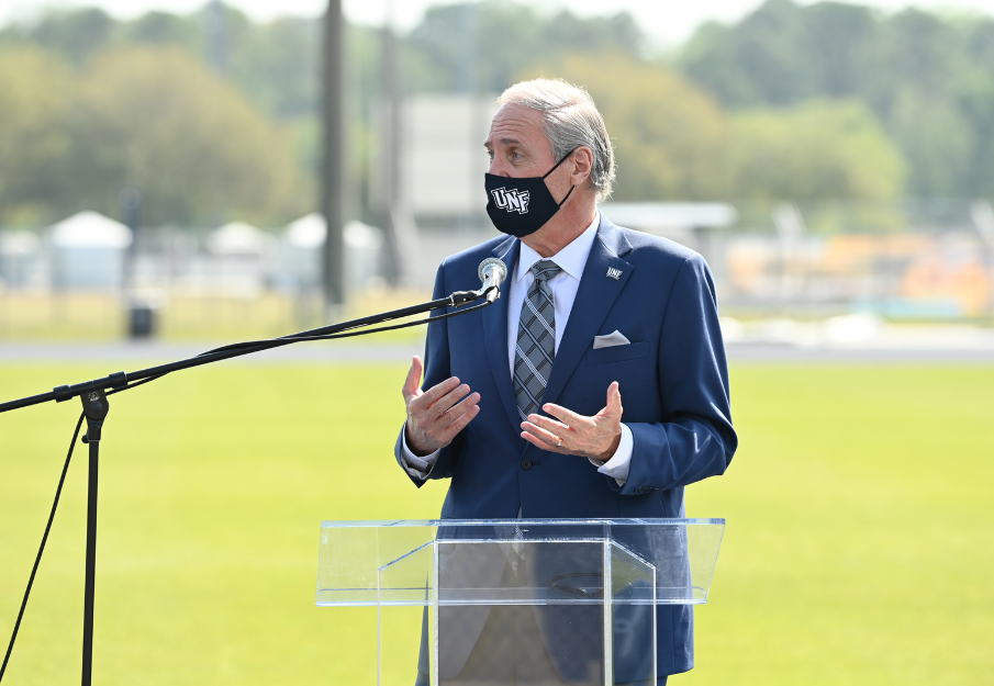 President Szymanski outside at a podium with a face mask on
