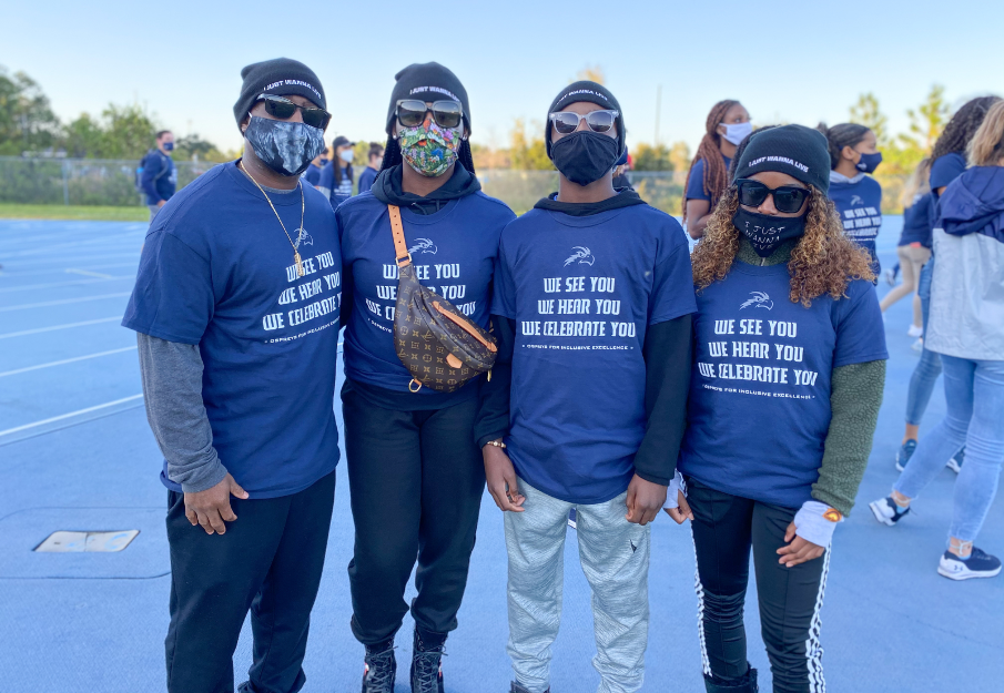 Group of students standing together outside in UNF diversity t-shirts