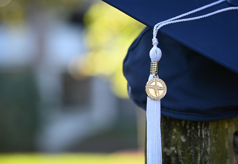 UNF graduation cap on wood post outside