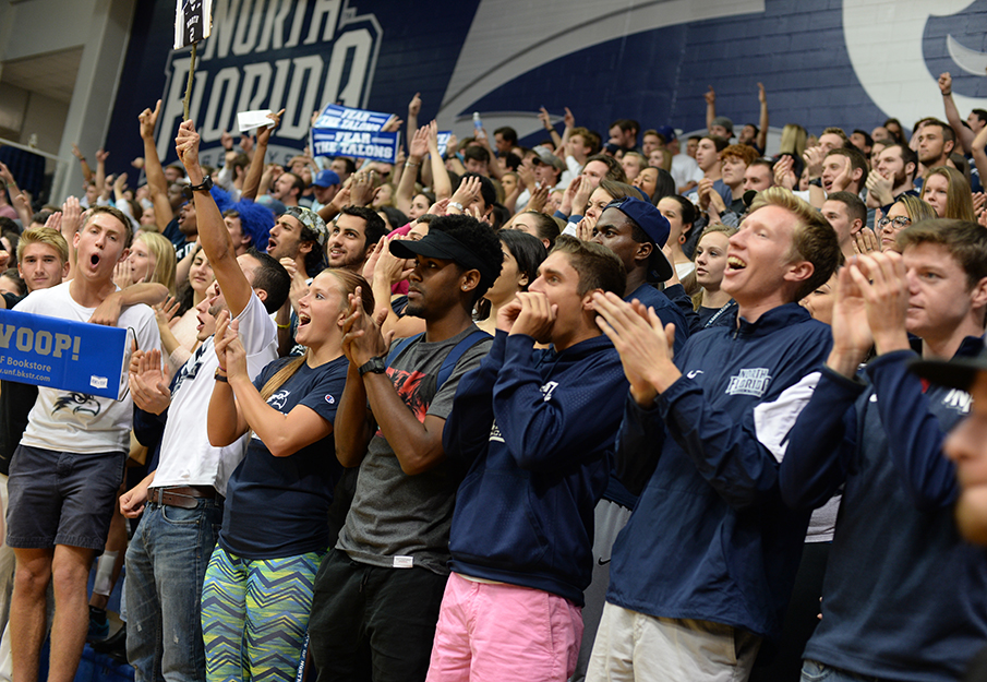 Students in crowd cheering at basketball game