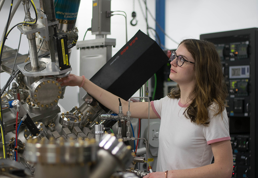 Female student using a piece of machinery