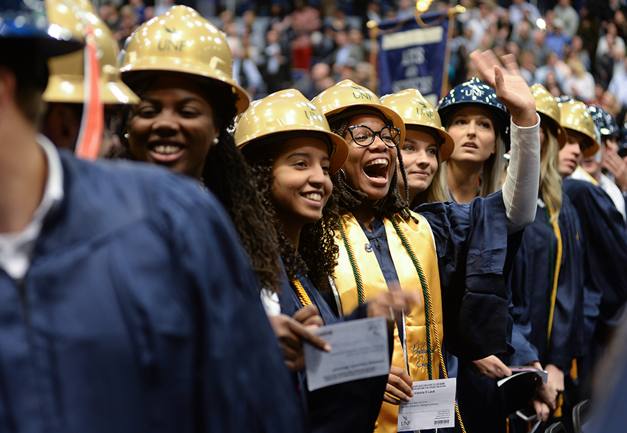 Construction graduates smiling and wearing hard hats