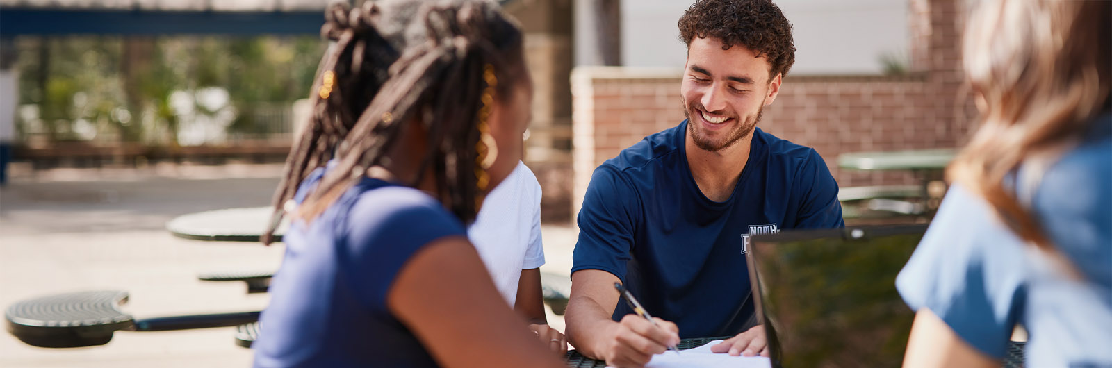 A group of students sitting outside smiling