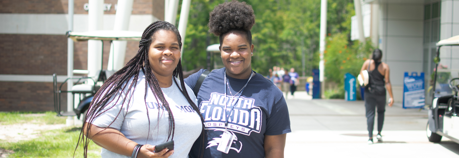 Mother and daughter in UNF t-shirts standing outside and smiling