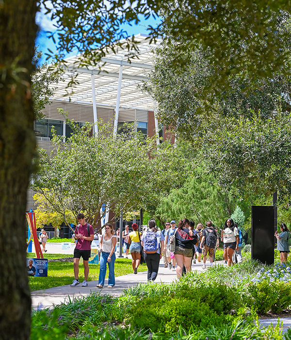 a crowd of students walking on campus