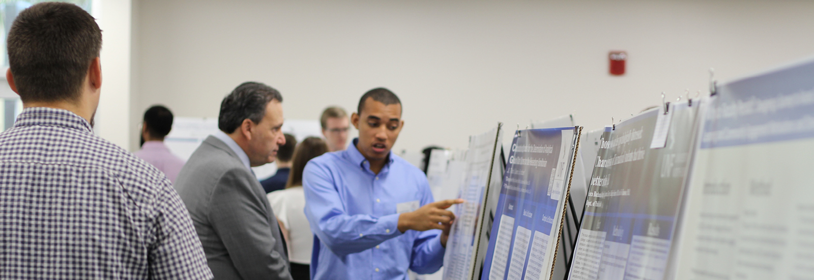 U-GLIDE UNF President discussing student's poster and project 