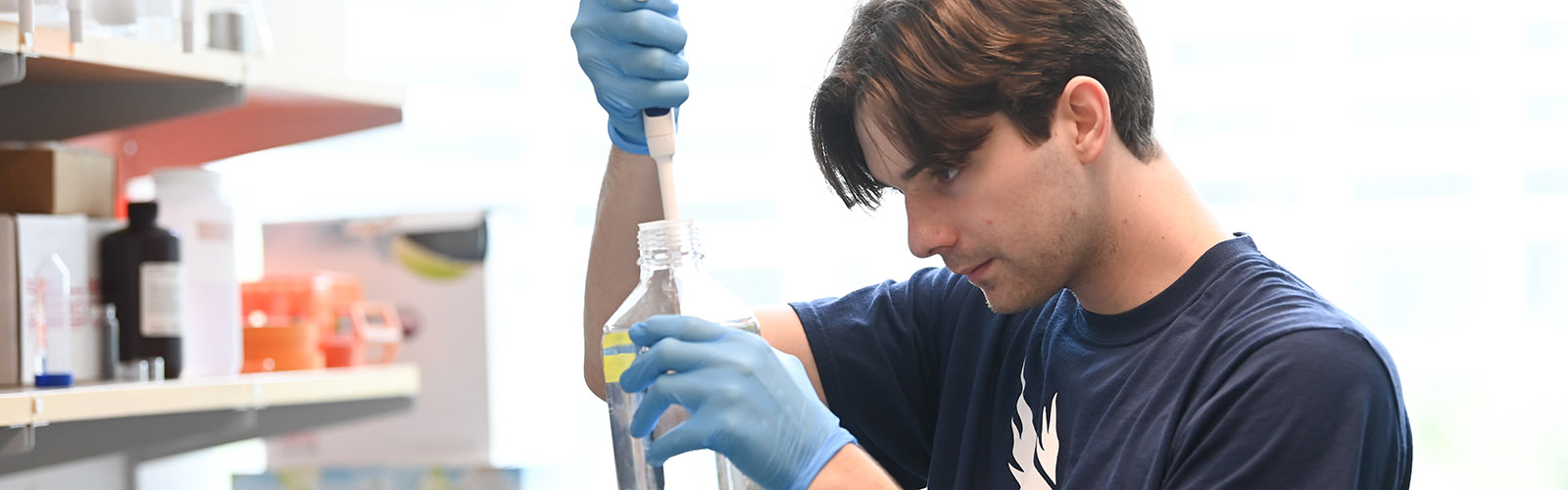 student working with a clear liquid in a bottle