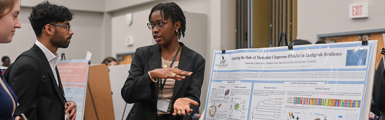 student explaining her research poster