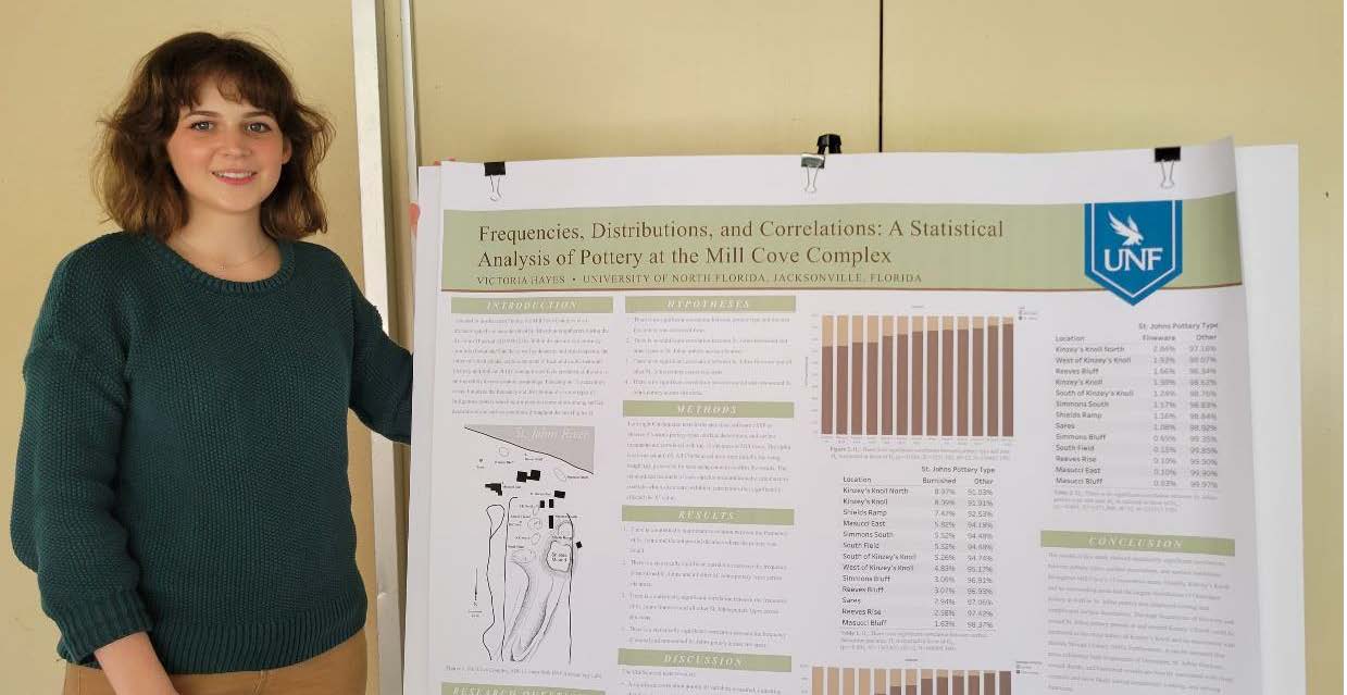 Vic Hayes standing with her research poster