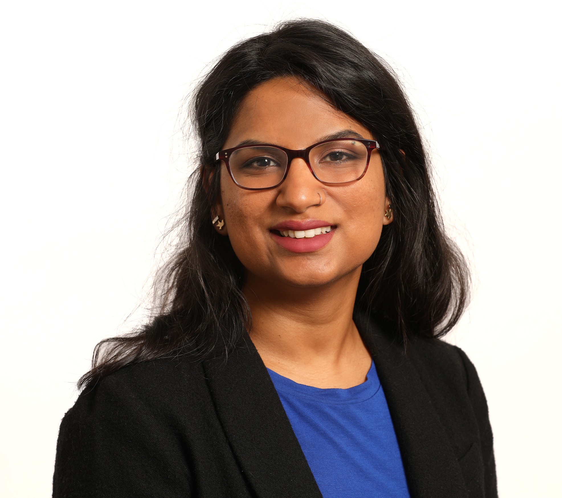 Dr. Rayaprolu is smiling and is wearing glasses, a blue shirt, and a black blazer. 
