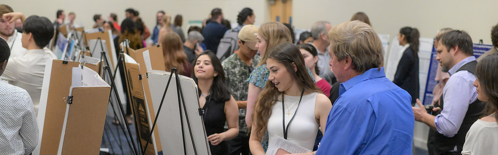 conference floor with students presenting at the Student Research Symposium