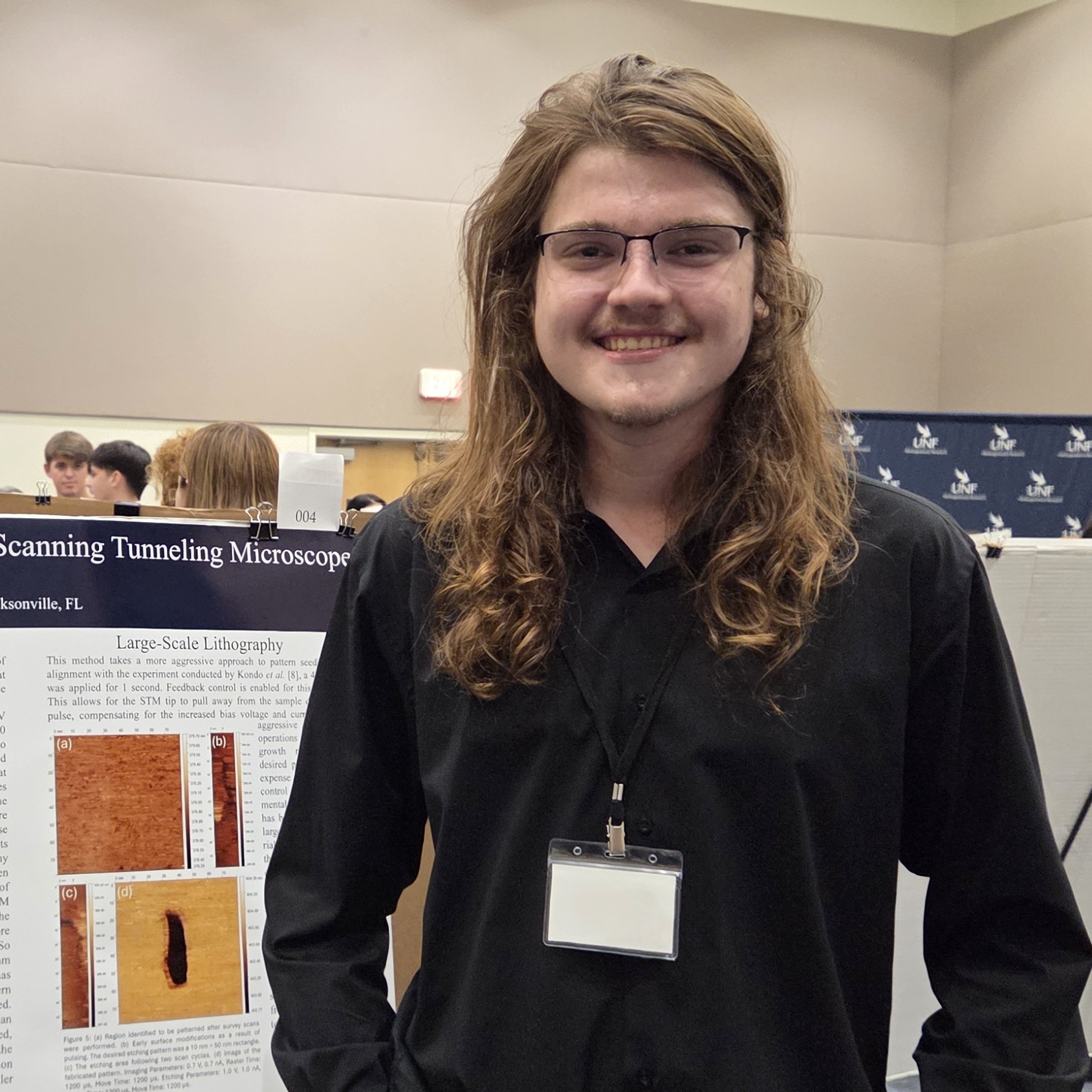 A man is standing by a research poster