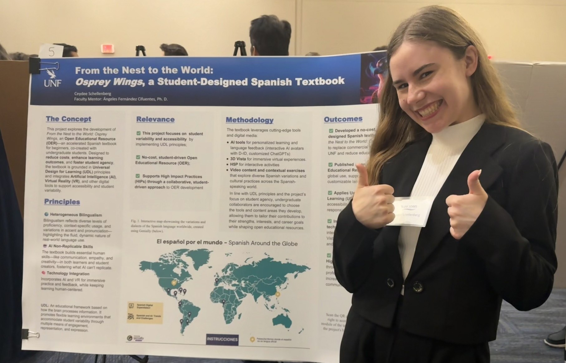 Ceydee standing in front of her research poster smiling with two thumbs up 