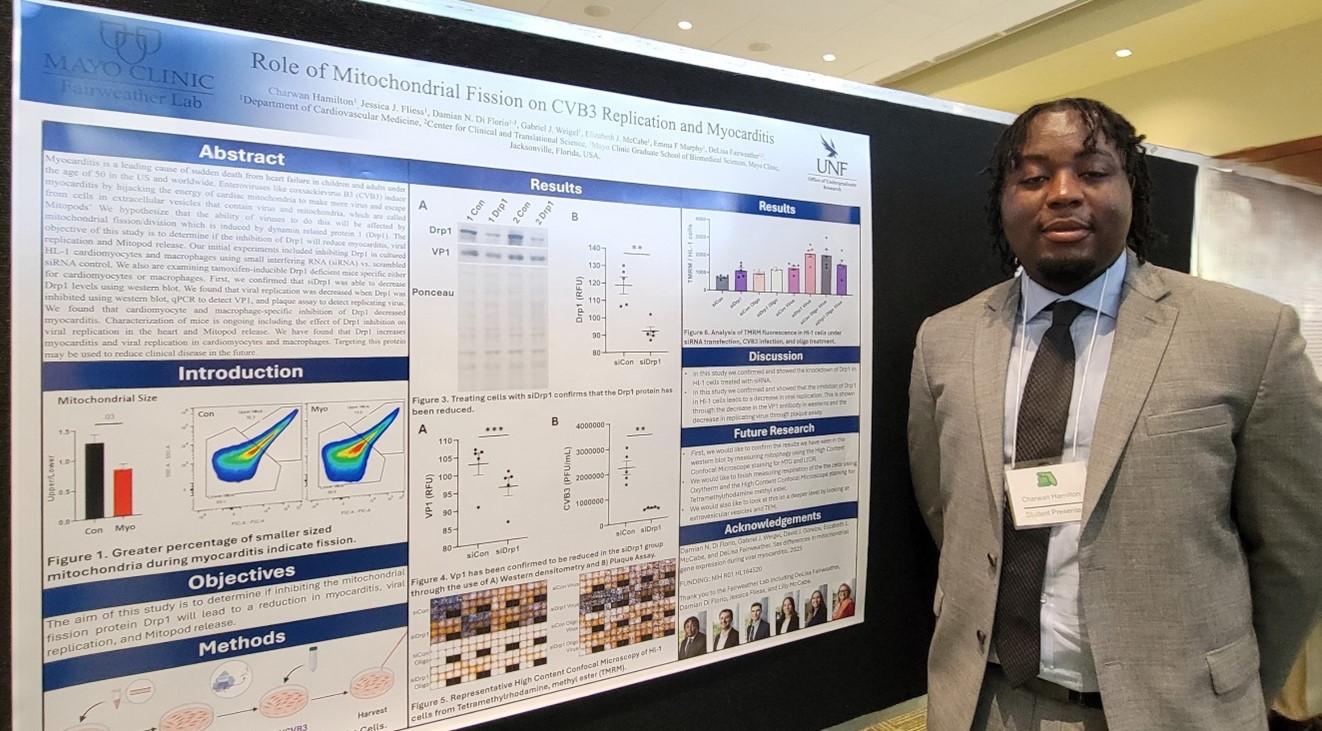 Charwan standing in front of his research poster. 