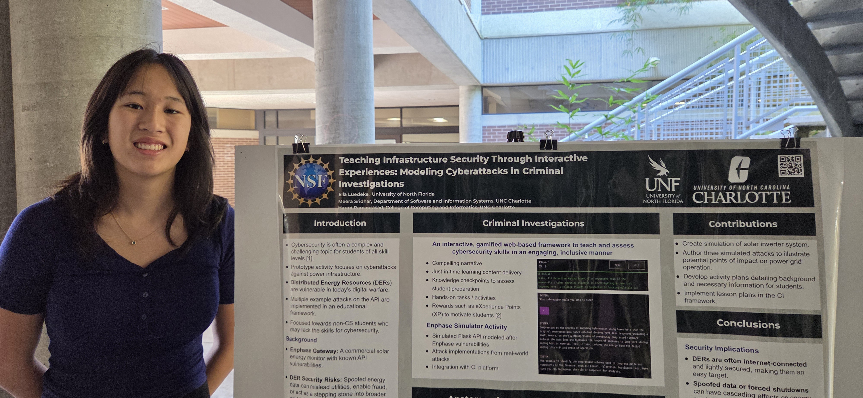 Ella is wearing a blue shirt and standing in front of her research poster outside. 