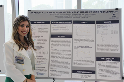 Gabby Khazal standing in front of her research poster.