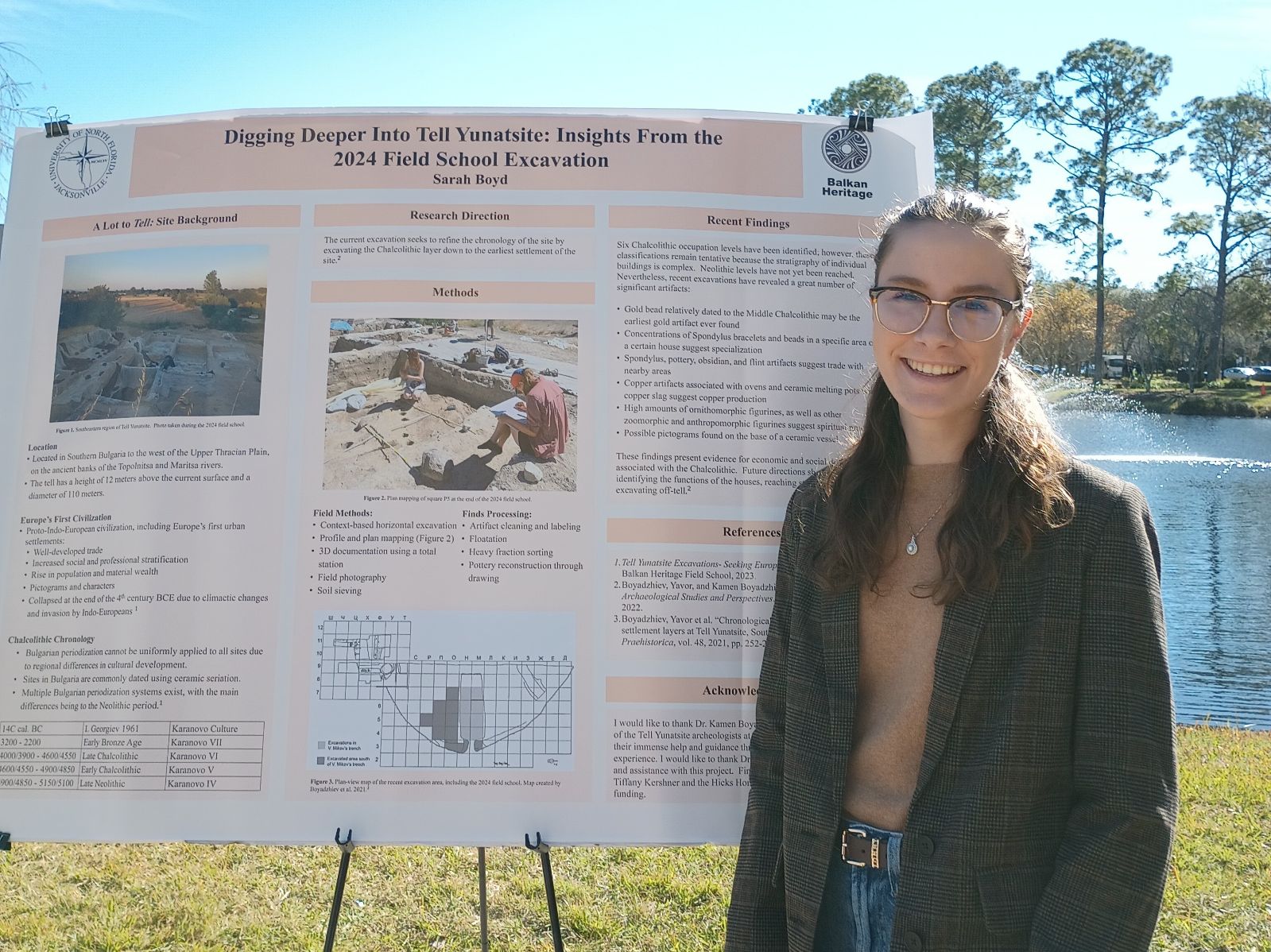Sarah Boyd standing in front of her research poster and smiling. 