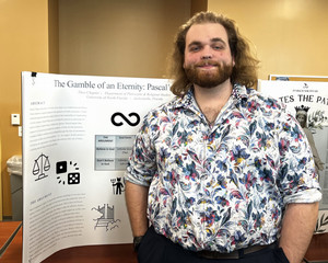 Theo Chapuis standing in front of his poster and smiling.