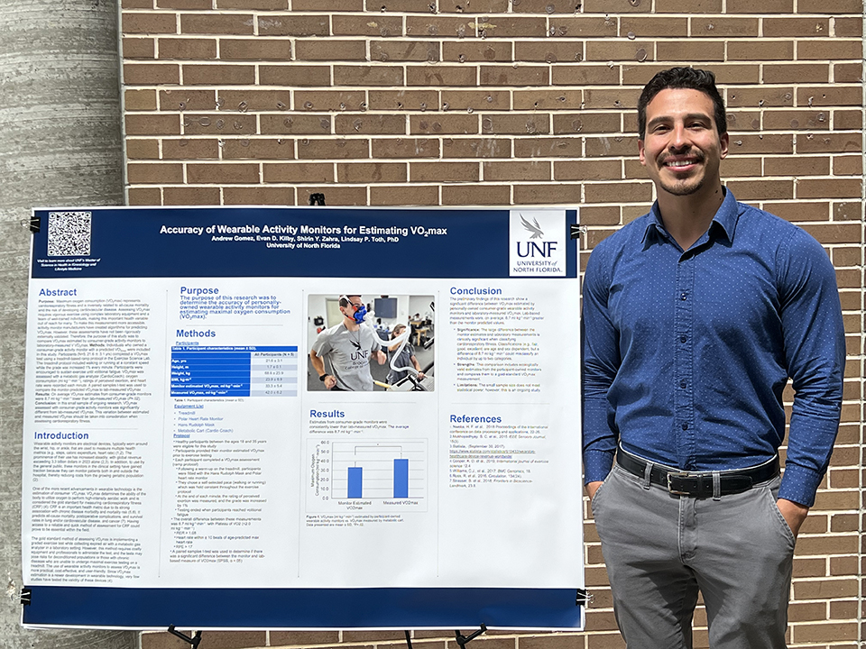 Andrew Gomez posing with his project poster