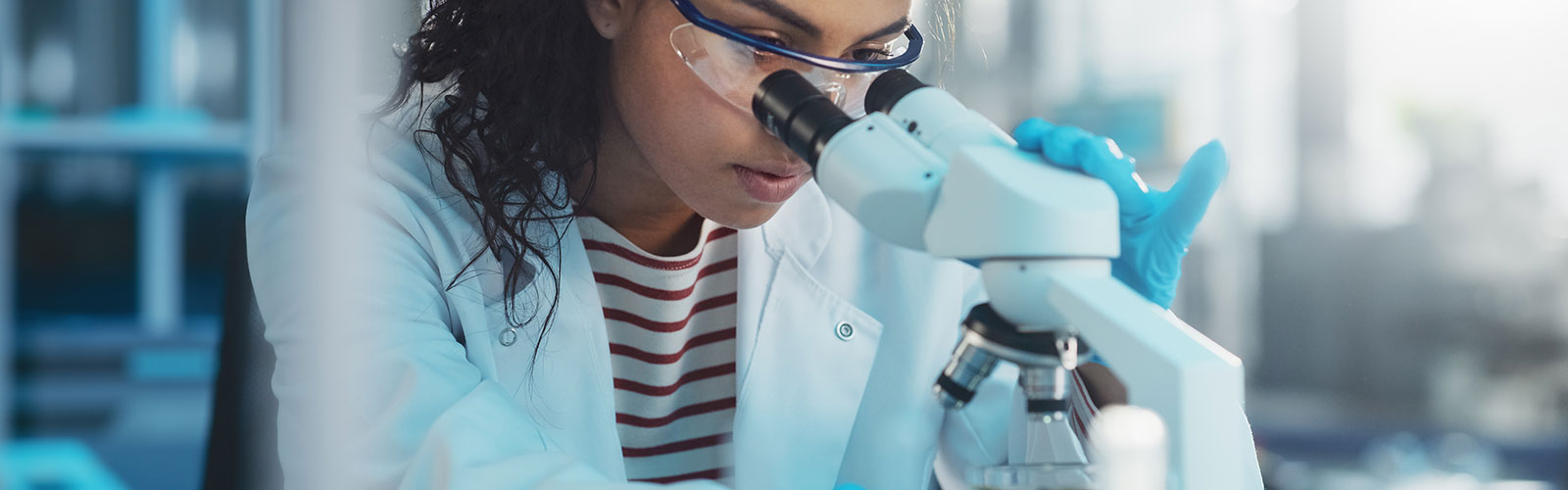 woman looking through a microscope