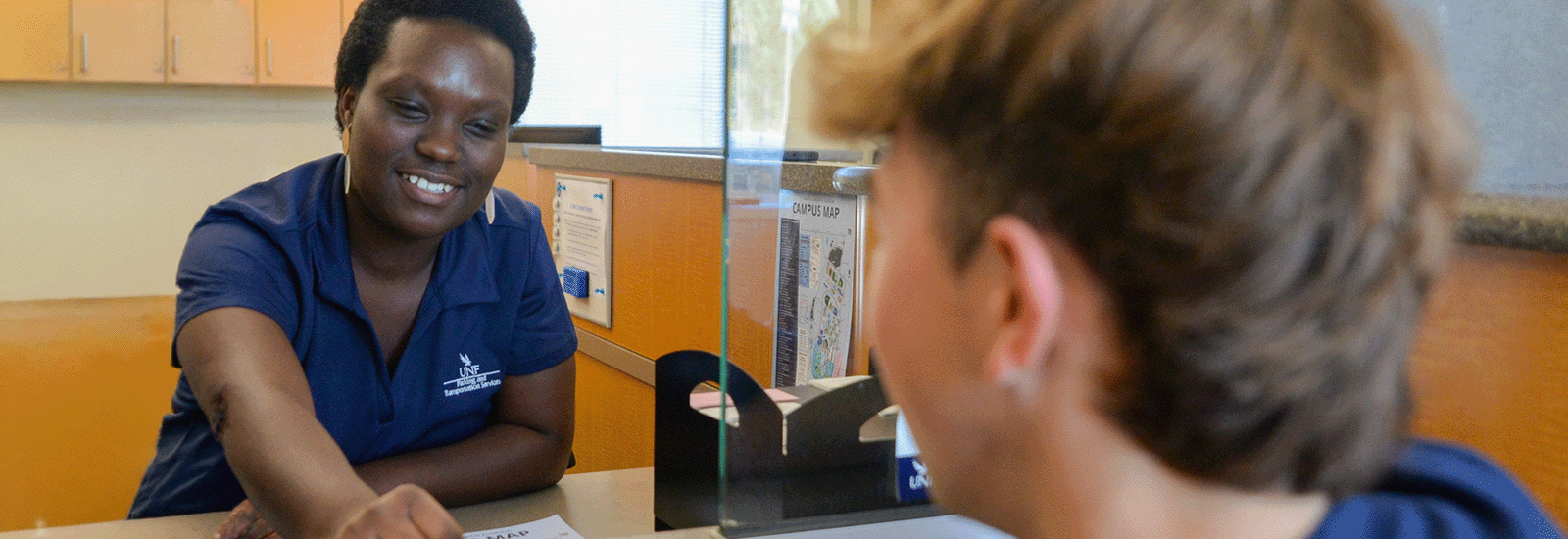 A student is being helped at the Parking Services lobby window
