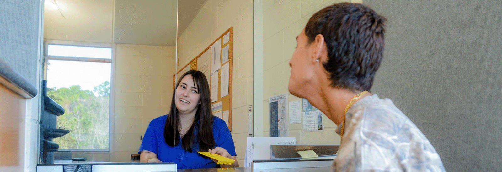 Student getting help with a parking ticket inside the parking services lobby