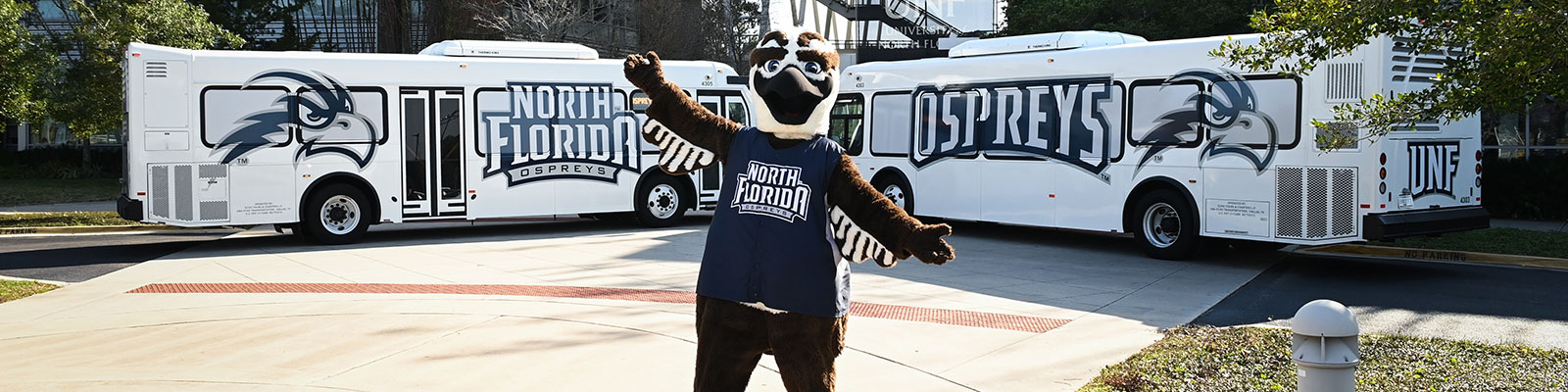 ozzie standing in front of two unf buses