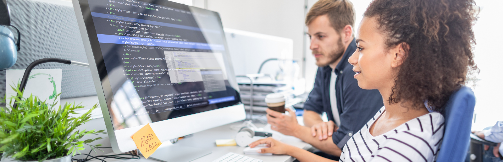 two people looking at code on a computer