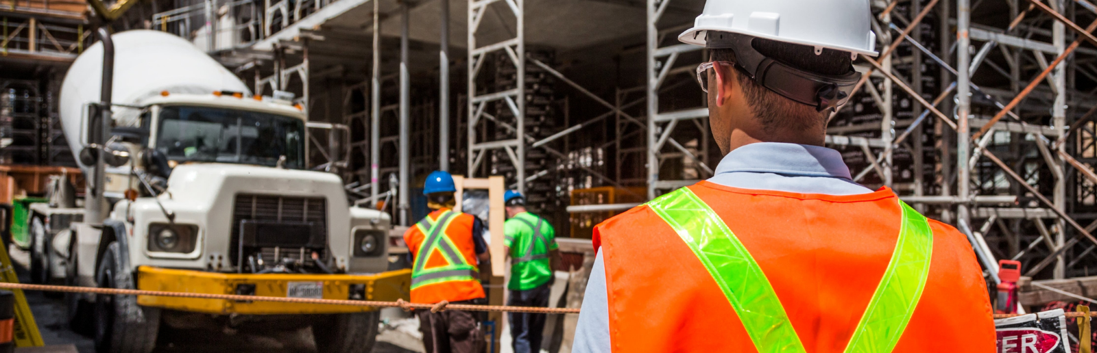 construction workers on a site in orange vests and hard hats on