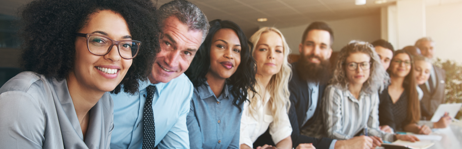 diverse group smiles at camera in business attire