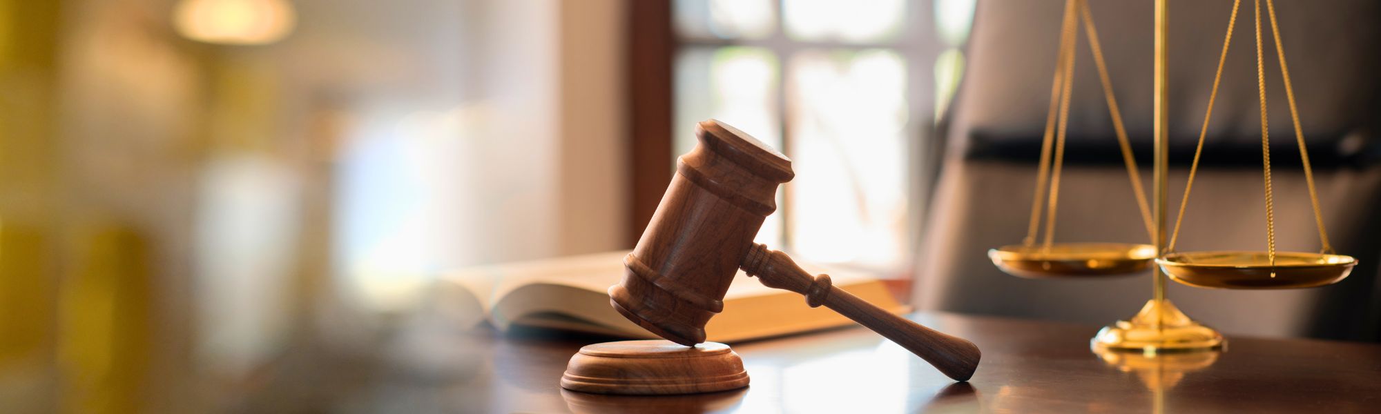 Desk with a gavel and scales in a courtroom