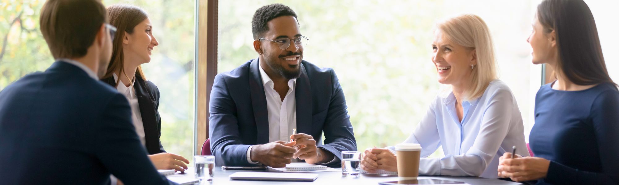 Smiling business people with suits having a meeting