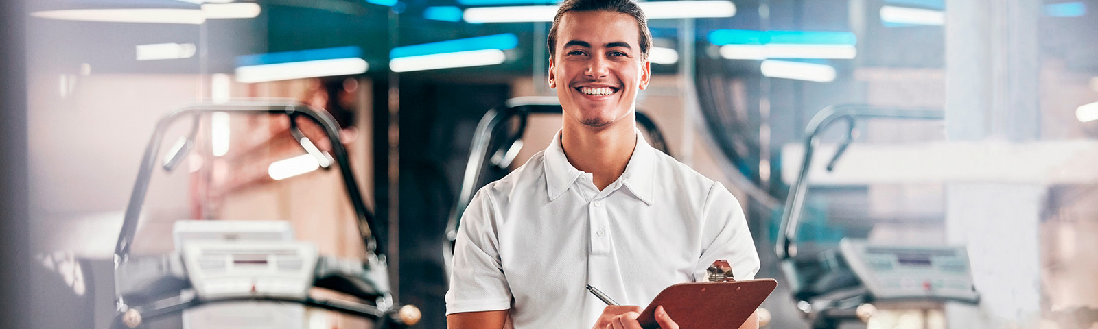 Personal trainer at a fitness club holding a clipboard