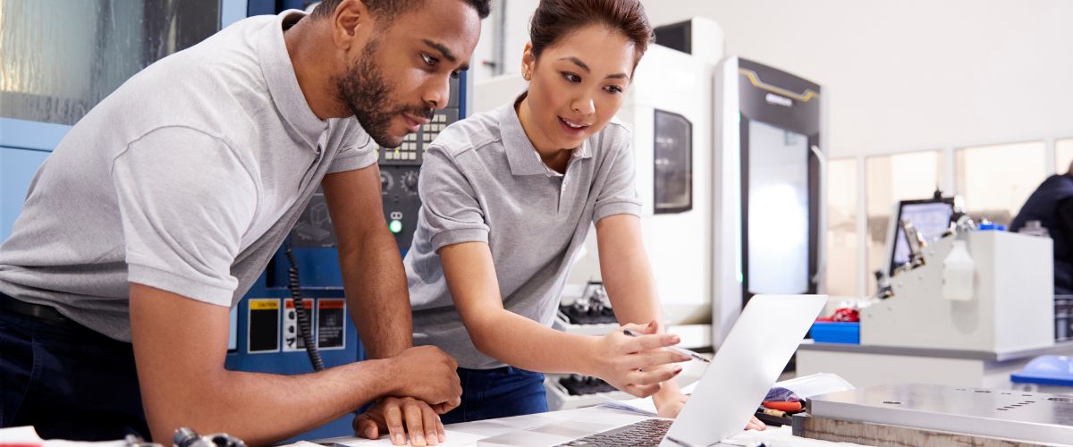 Production workers checking a CAD drawing