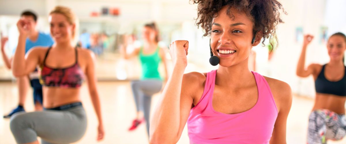 Female instructor with headset in fitness class