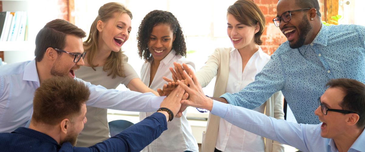 Happy group of people giving each other a high five