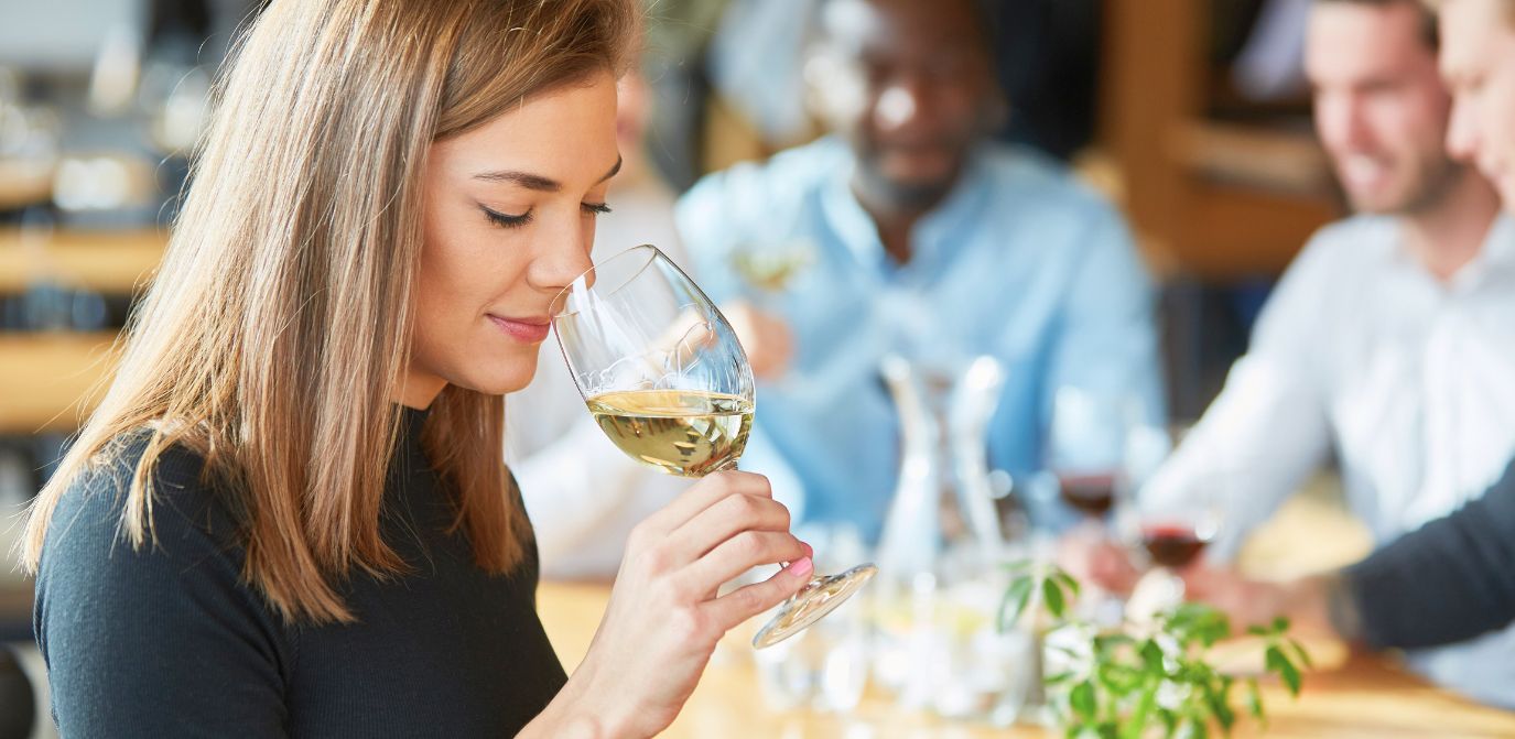 Woman tasting a glass of white wine