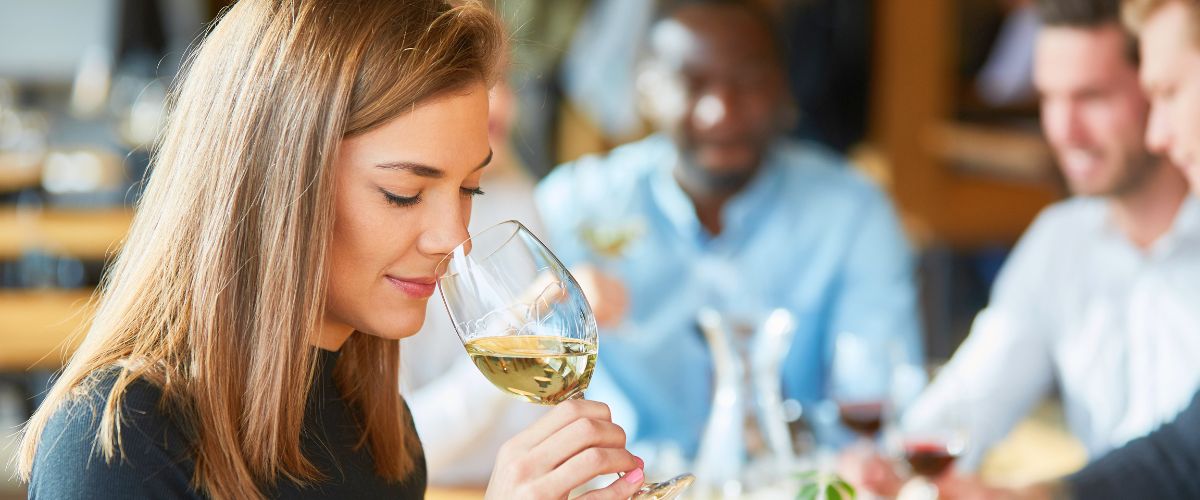 Woman tasting a glass of white wine