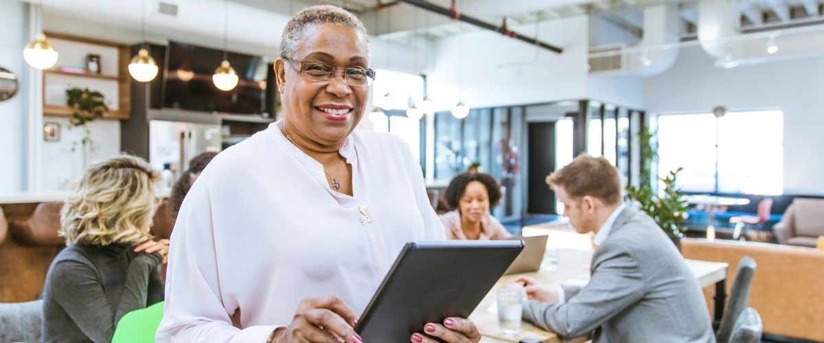 Smiling woman with a tablet in office