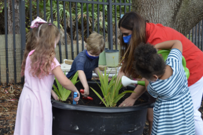 Teacher with students watering plants