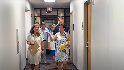 Brooks college of health staff walking through a hallway