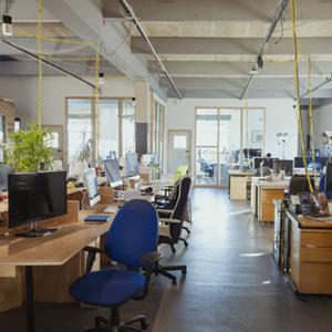 empty office with desks, chairs, and monitors