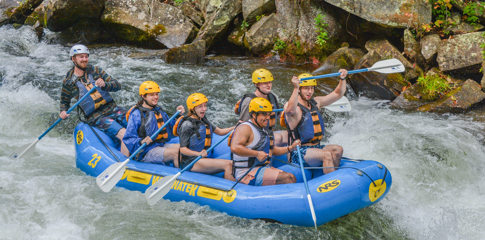 people paddling on a raft